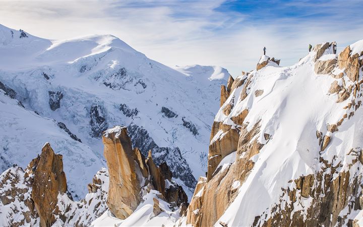 A hiker on a snowy peak MacBook Air wallpaper