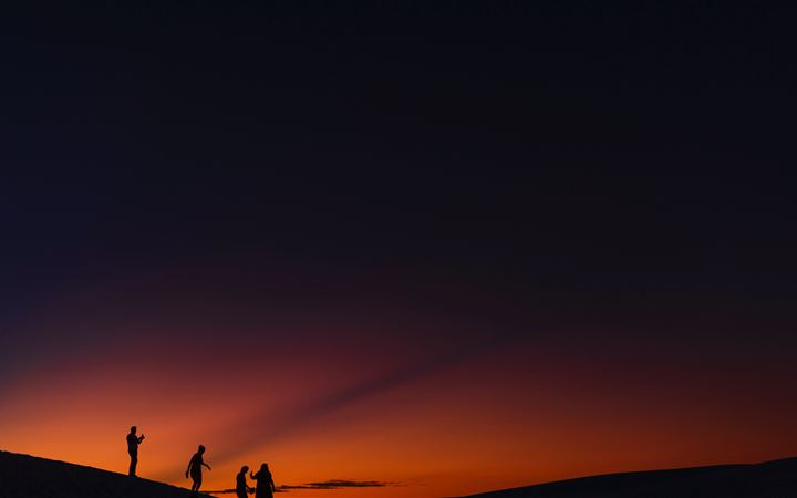 four people standing during golden hour MacBook Air wallpaper