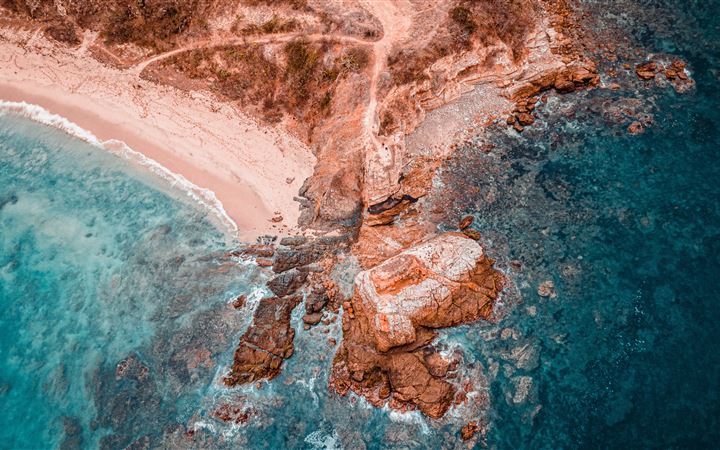 aerial photography of brown rock formation beside MacBook Pro wallpaper
