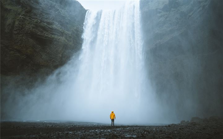 person standing near waterfalls MacBook Pro wallpaper