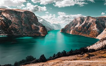 body of water between brown mountains All Mac wallpaper