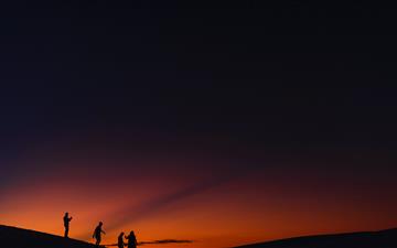 four people standing during golden hour MacBook Air wallpaper