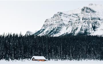 snow covered cabin near forest MacBook Air wallpaper