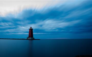 red and white lighthouse on top of hill iMac wallpaper