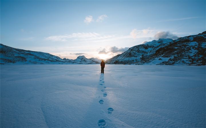 person walking on snow field leaving foot prints MacBook Air wallpaper