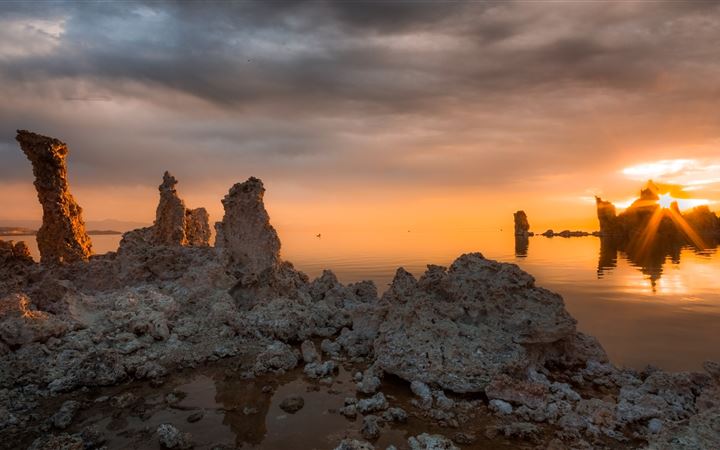 rock formations near calm body of water All Mac wallpaper