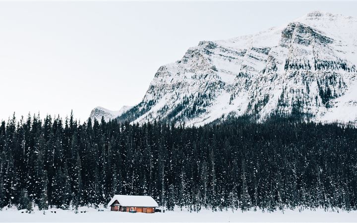 snow covered cabin near forest MacBook Air wallpaper
