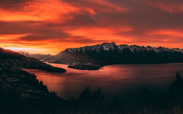 body of water near mountains at golden hour MacBook Pro wallpaper