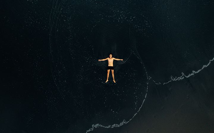 man lying on water MacBook Pro wallpaper