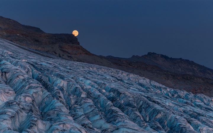 moon rising over a glacier with mountains MacBook Pro wallpaper