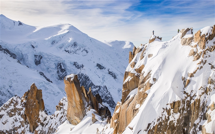 A hiker on a snowy peak Mac Wallpaper