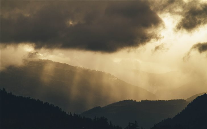 Faint sun rays over hills Mac Wallpaper
