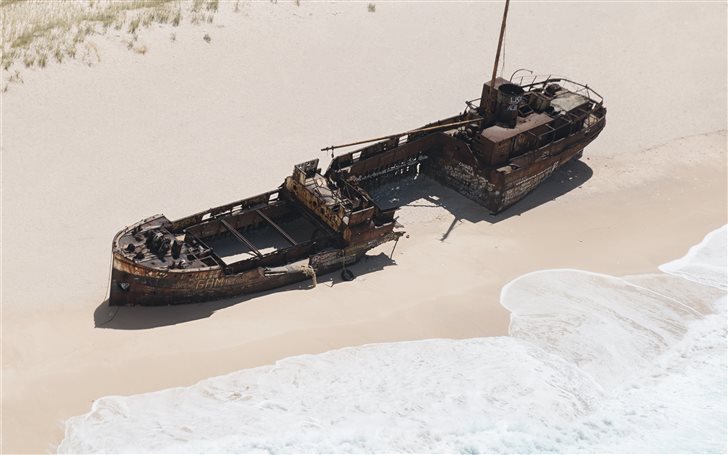 wrecked brown ship on sea... Mac Wallpaper