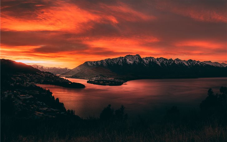 body of water near mountains at golden hour Mac Wallpaper