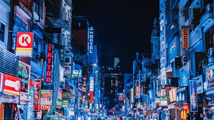 people between city buildings at night Mac Wallpaper