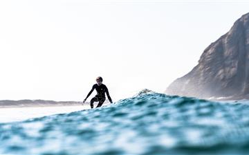 person surfboarding MacBook Pro wallpaper