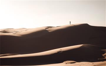 silhouette of person standing on brown sand All Mac wallpaper