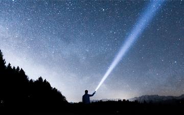 silhouette of person holding flashlight during nig iMac wallpaper