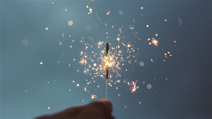 person holding lighted sparklers Mac Wallpaper