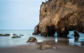 brown rock formation on sea shore during daytime iMac wallpaper