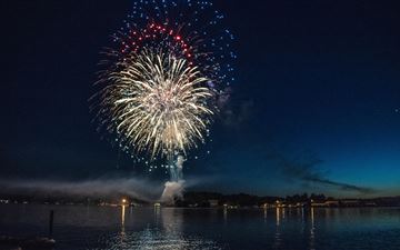 fireworks explosion above water body 8k MacBook Pro wallpaper